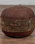 Brown rattan ottoman with wood band and weathered patina, round shape, inspired by vintage Chinese hat box.