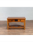 Natural wood Chinese side table with two drawers and crackled ice shelf, on wooden floor against white brick wall.