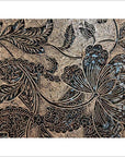 Close-up of vintage copper Batek ink block with detailed floral and leaf carvings, showing intricate botanical textures.