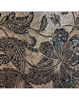 Close-up of vintage copper Batek ink block with detailed floral and leaf carvings, showing intricate botanical textures.