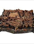 Vintage copper Batek ink block with peacock and floral motif, close-up of carved surface for textile or paper printing.