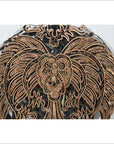 Close-up of a vintage copper Batek ink block with ornate leaf-like patterns on a white background.