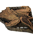 Close-up of vintage copper Batek ink block with intricate bird design, used for textile printing.