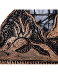 Close-up of vintage copper Batek ink block with ornate abstract animal and leaf motifs.