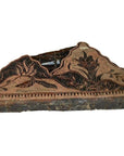 Close-up of vintage copper Batek ink block stamp with intricate floral patterns, used in textile design.