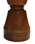 Close-up of a weathered brown wooden hand-carved vintage candle holder with Dutch influence and textured surface.