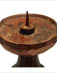 Brown wood hand carved candle holder with Dutch influence, round flat top, metal spike, surface crack, close-up view.