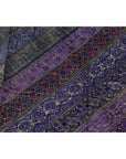 Close-up of purple silk fabric with silver and gold floral embroidery in diagonal stripes.