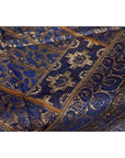Close-up of purple silk fabric with floral and geometric embroidery in purple, silver, and gold.