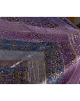Close-up of purple silk fabric with silver and gold embroidery and floral designs, vintage Indian textile.