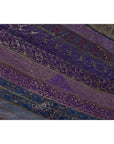 Purple silk fabric with diagonal embroidery in purple, silver, and gold tones, close-up.