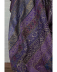 Purple silk fabric with silver and gold embroidery in floral and geometric patterns, close-up.