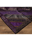 Purple silk fabric with silver and gold embroidery accents on a wooden surface.
