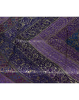 Close-up of purple silk fabric with silver and gold embroidery in detailed patterns.