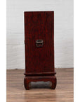 Red Negora lacquer and metal Japanese display cabinet with gilded calligraphy on curved legs, indoors.