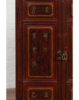 Close-up of red lacquered Japanese display cabinet with metal handles and gold calligraphy detailing.