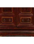 Close-up of red Negora lacquer and gilded calligraphy on Japanese wood display cabinet lower panels.