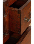 Close-up of brown wood drawer with metal handle, dovetail joints, in vintage Javanese Japanese-style cabinet.