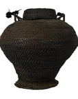 Close-up of large dark brown woven basket from the Philippines with wide body, narrow base, and top handles.