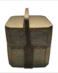 Brown woven rattan basket with large wooden handle and reinforced edges on a white background.