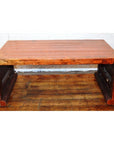 Rectangular lacquered waterfall table with thick legs on wooden floor, set against a white brick wall.