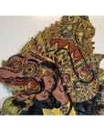 Brown cowhide Wayang Kulit Balinese shadow puppet with intricate patterns, bulging eyes, fierce expression, tall headdress.