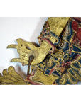 Close-up of gold-patterned Balinese Wayang Kulit cowhide shadow puppet hand with ornate detailing.