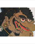 Close-up of an antique brown cowhide Wayang Kulit Balinese shadow puppet with curly hair and bold facial features.