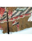 Close-up of colorful cowhide Wayang Kulit Balinese shadow puppet feet in a zigzag garment.