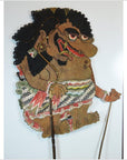 Close-up of antique Balinese Wayang Kulit shadow puppet, carved cowhide with bold features and ornate patterned attire.