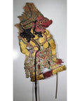 Close-up of red and yellow Wayang Kulit Balinese cowhide shadow puppet with intricate patterned clothing.