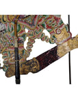 Close-up of colorful cowhide Wayang Kulit Balinese shadow puppet arm holding an intricately detailed staff.