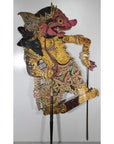 Close-up of Balinese Wayang Kulit shadow puppet, carved cowhide with intricate designs, two rods, balanced on one leg.
