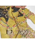 Close-up of a vibrant Balinese Wayang Kulit shadow puppet made from cowhide with intricate patterns and curly black hair.