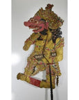 Colorful cowhide Wayang Kulit Balinese shadow puppet with ornate costume and exaggerated facial features, close-up.