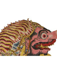 Balinese cowhide shadow puppet with pink snout, bulging eye, and striped mane in side profile.