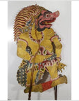 Yellow cowhide Wayang Kulit Balinese shadow puppet with red face and ornate headdress, close-up view.