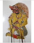 Yellow cowhide Wayang Kulit Balinese shadow puppet with ornate clothing and dramatic face, Indonesia, close-up.