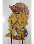 Yellow cowhide Wayang Kulit Balinese shadow puppet with ornate clothing and dramatic face, Indonesia, close-up.