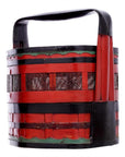 Close-up of a red and black wedding basket with green accents, large handle, and decorative cut-out side patterns.