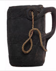 Close-up of a dark wood mug with handle and rope looped through a hole near the rim, Wooden Indian Pitcher With Rope.