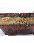 Close-up of red and gold woven bamboo offering basket with gilt décor, woven rim, and handles.