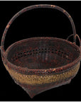 Natural bamboo basket with gold decorative band and sturdy handle, close-up on black background.