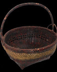 Natural bamboo basket with gold decorative band and sturdy handle, close-up on black background.