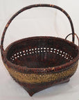 Red and gold woven bamboo offering basket with curved handle, close-up on white background.