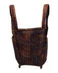 Natural rattan basket with tall looped handles and rounded rectangular shape, top view.
