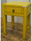 Distressed yellow wood side tables with horse hoof feet and single drawer, shown on a wooden floor.