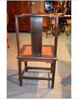 Dark brown wood Yoke Back Chair with burl wood seat, wide flat backrest, and square legs on a wooden floor.