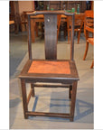 Dark brown Chinese yoke back chair with tall straight backrest and flat burl wood seat, front view.