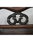 Dark brown Yumu wood Chinese chair with hand-carved décor and lacquered finish, shown against a neutral background.